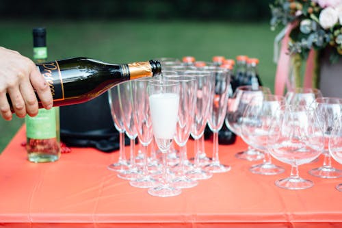 Photo Of Person Pouring Wine On Glass Wine Glass