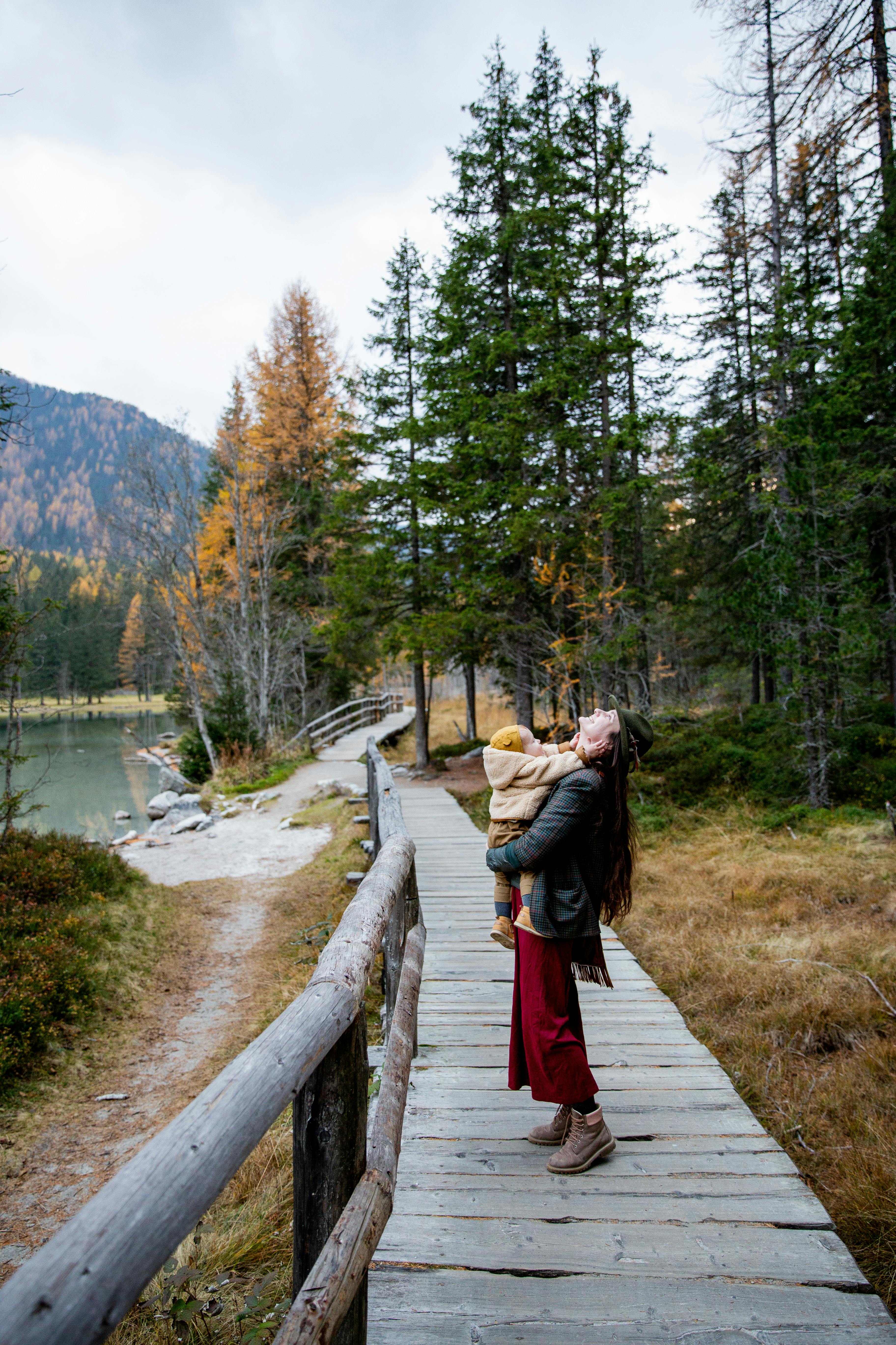 photo of woman carrying baby