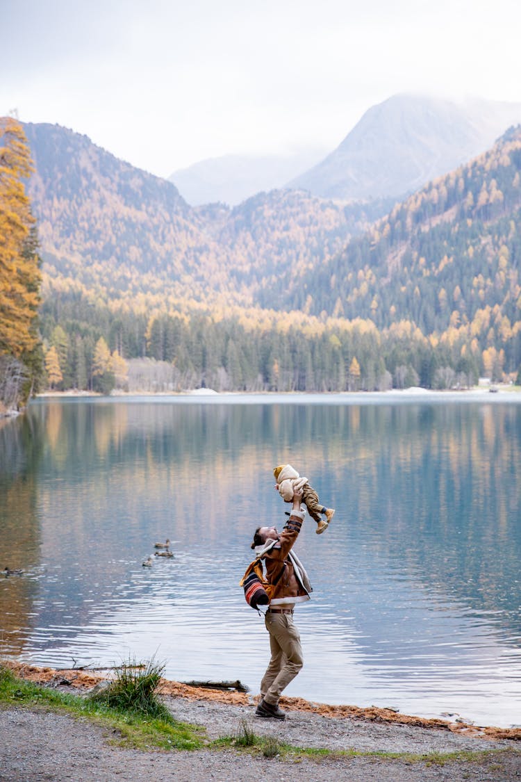 Father And Child Near Body Of Water