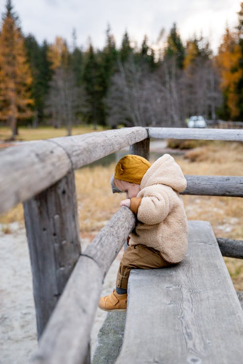 Photo Of Baby Leaning On Wooden Fence