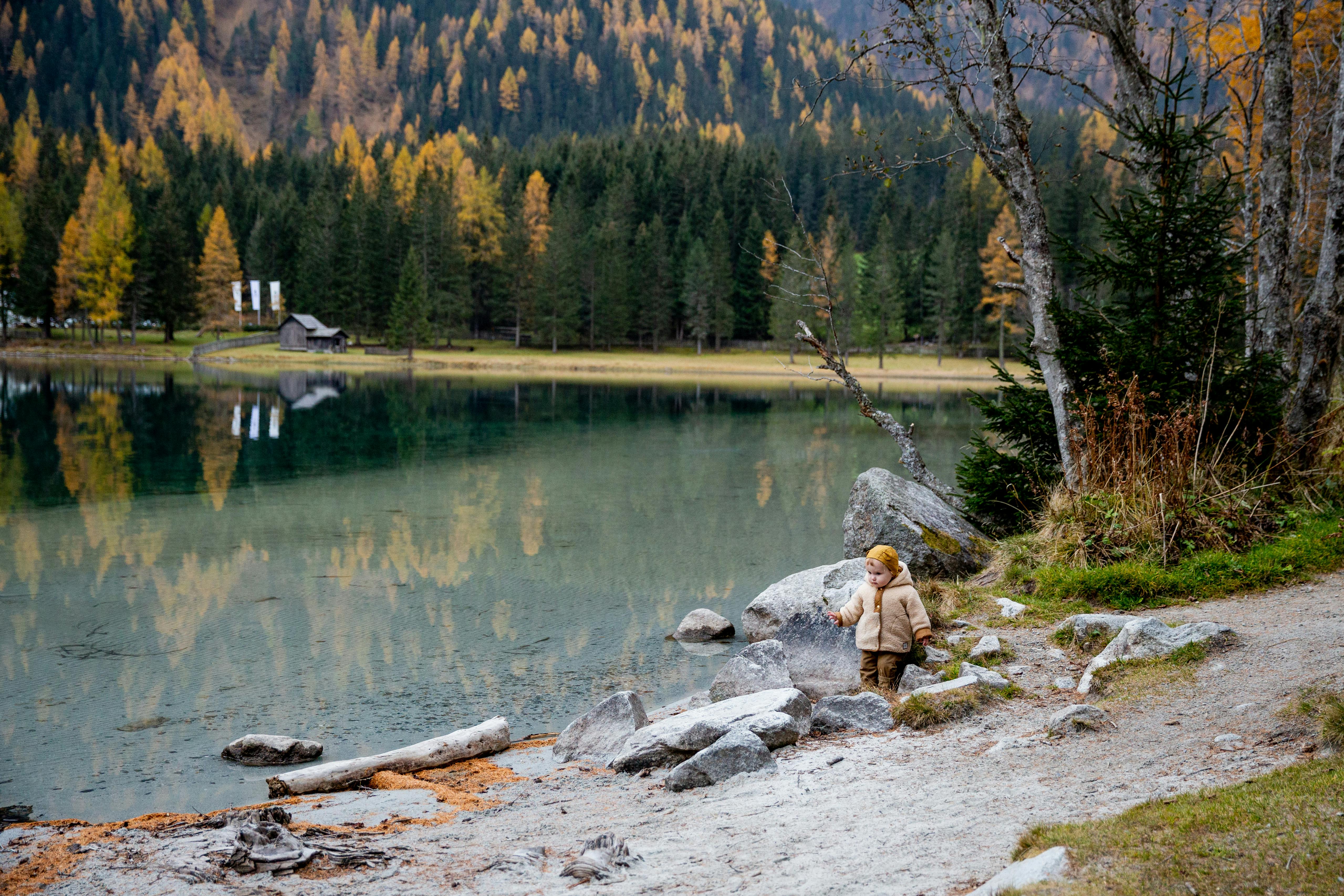 photo of baby walking on lakeside