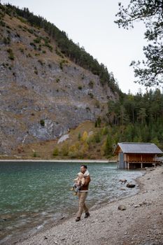 在风景秀丽的高山湖边，一位父亲带着他的孩子，展现了自然与家庭的纽带