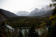 一个宁静的高山湖泊，周围环绕着茂密的森林和高耸的山峰，展现出最美的自然风光