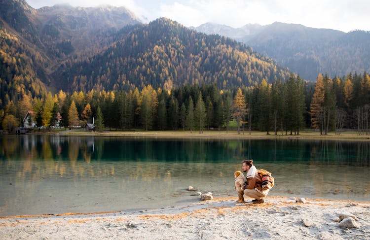 Man And Child Sitting On Shore