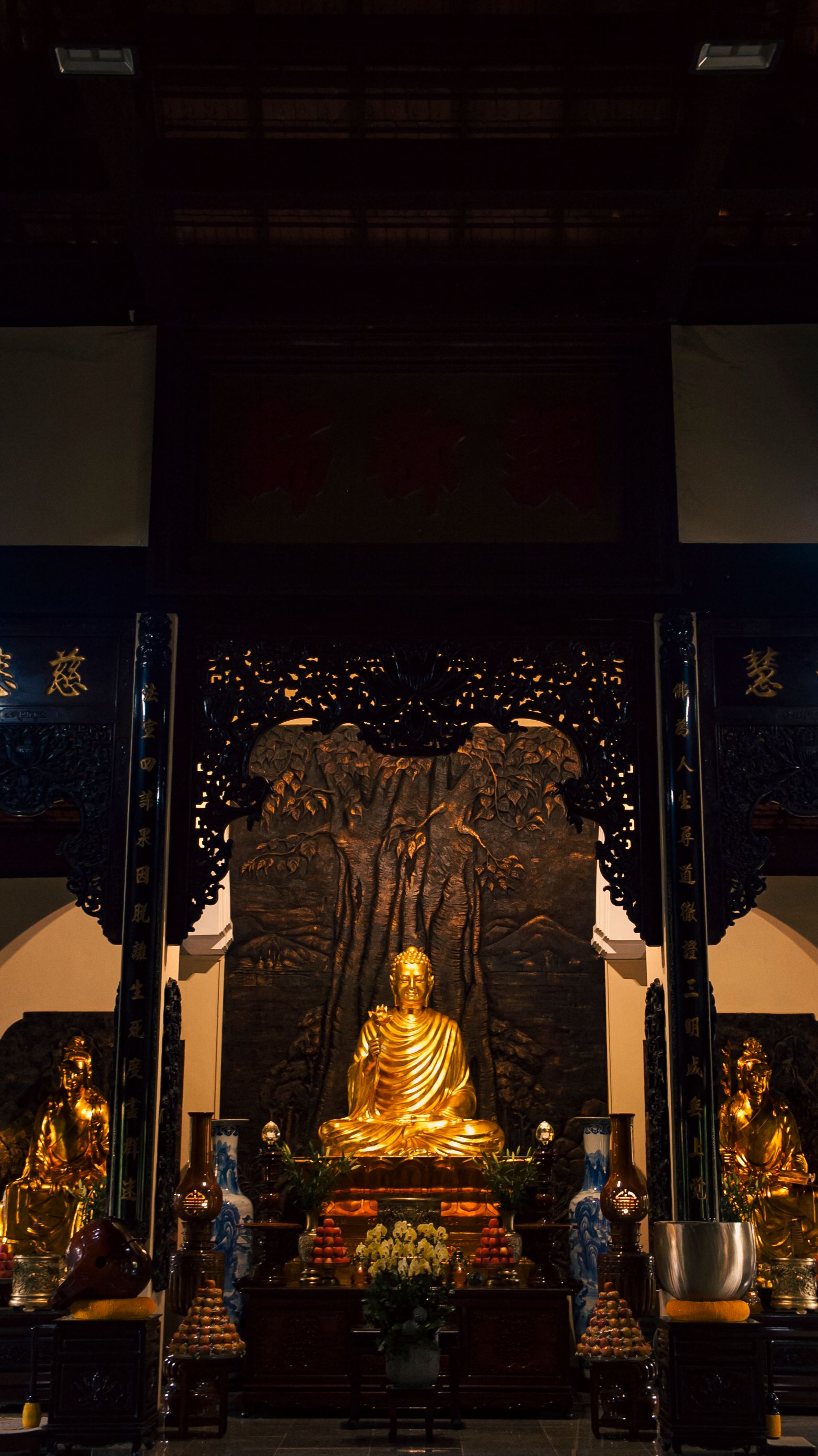 Golden Buddha statue inside a traditional Vietnamese temple, showcasing intricate carvings and serene atmosphere.