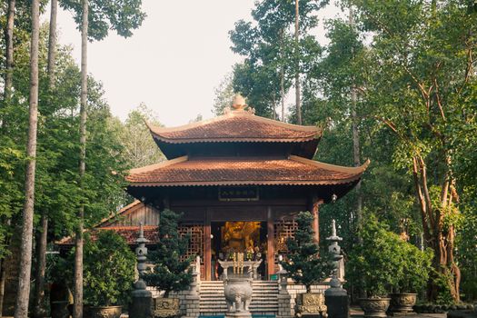 Serene Buddhist temple surrounded by lush greenery in Đồng Nai, Vietnam, showcasing traditional architecture.