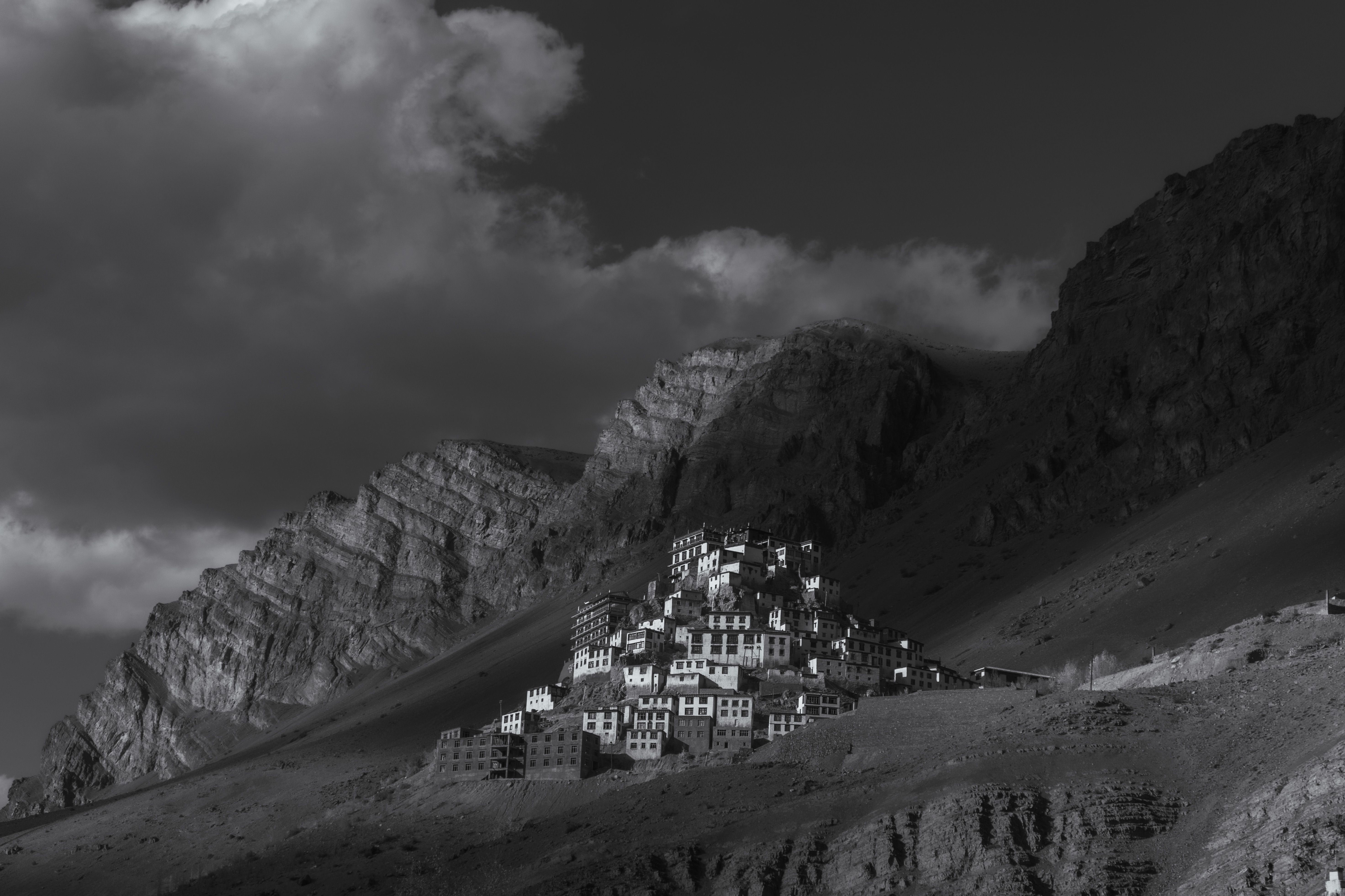 Dramatic black and white photo of Key Monastery nestled on a steep mountain in the Spiti Valley.