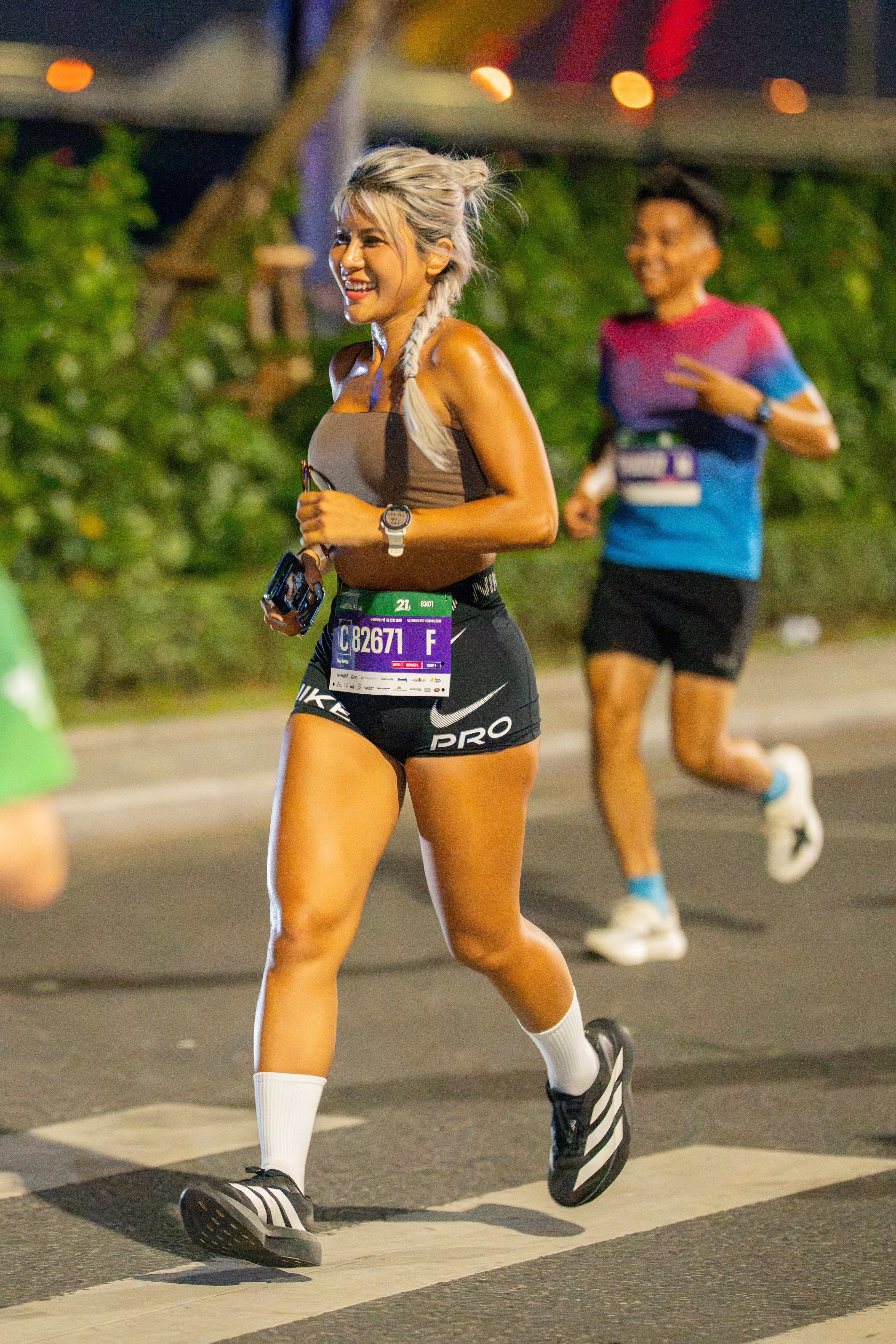 Two runners in a nighttime marathon, showing energy and determination.