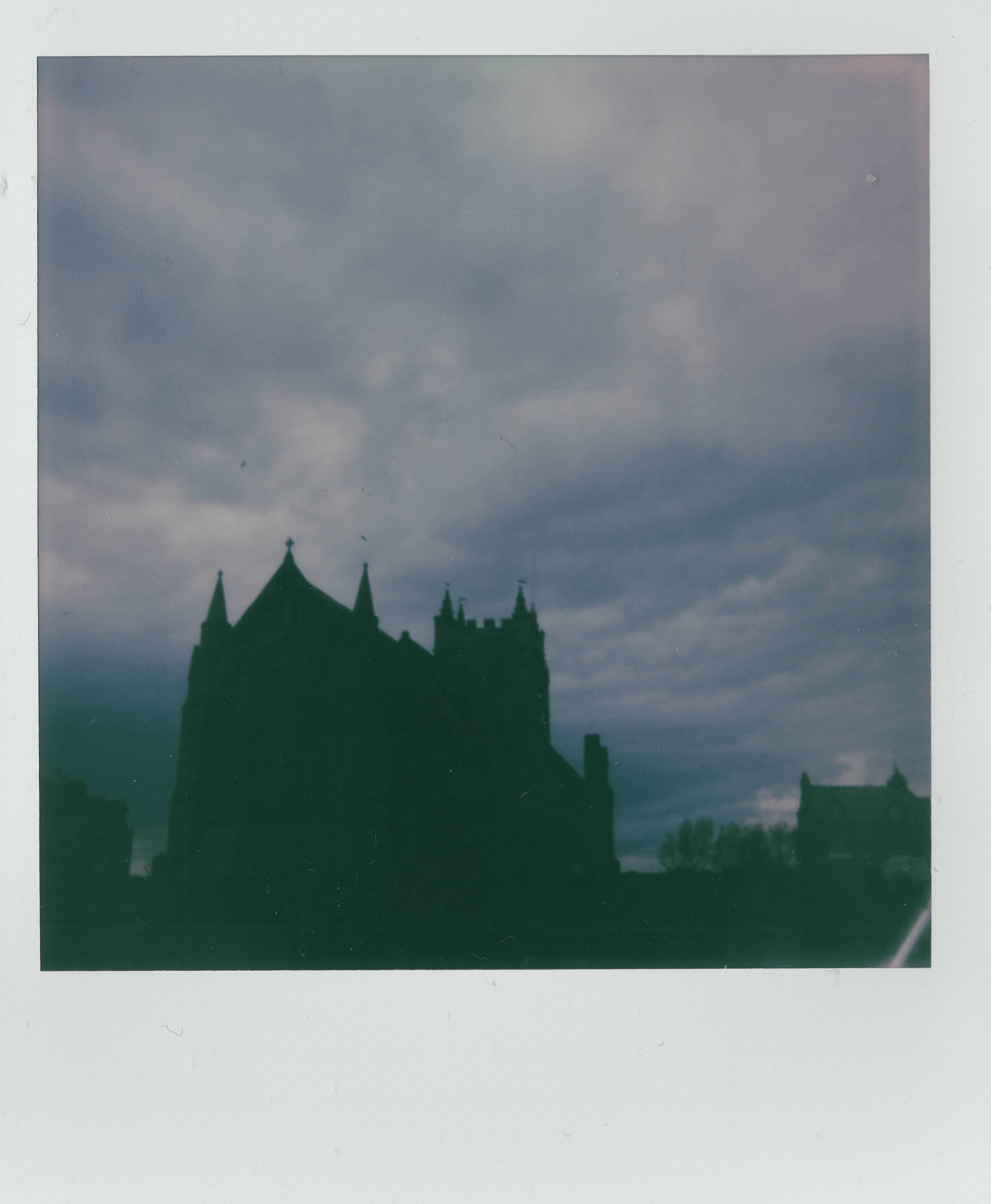 Atmospheric instant photo of a church silhouette under a cloudy sky in Hartlepool, UK.