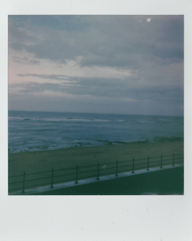 Retro Polaroid photo capturing Hartlepool's serene seaside under a moody sky.