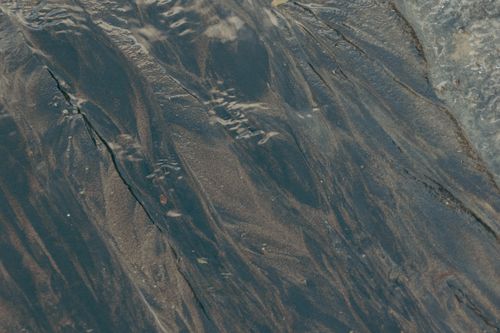 Free Close-up photo of textured sand patterns with water reflections on a New Zealand beach. Stock Photo