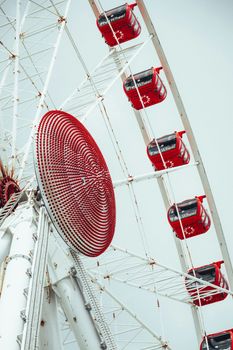 Close-up view of a Ferris wheel with red gondolas, ideal for travel and amusement themes.