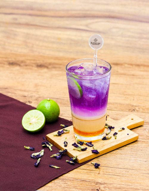 Free Vibrant iced butterfly pea lime drink served with fresh limes, creating a refreshing vibe. Stock Photo