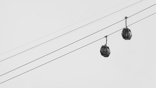 Free Minimalist black and white image of cable cars suspended in the sky. Stock Photo