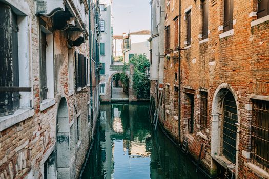 Serene Venetian canal framed by historic brick buildings, reflecting the timeless architecture of Venice.
