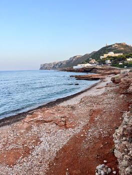 Beautiful Mediterranean coast with rocky shoreline and distant cliffs in Spain.