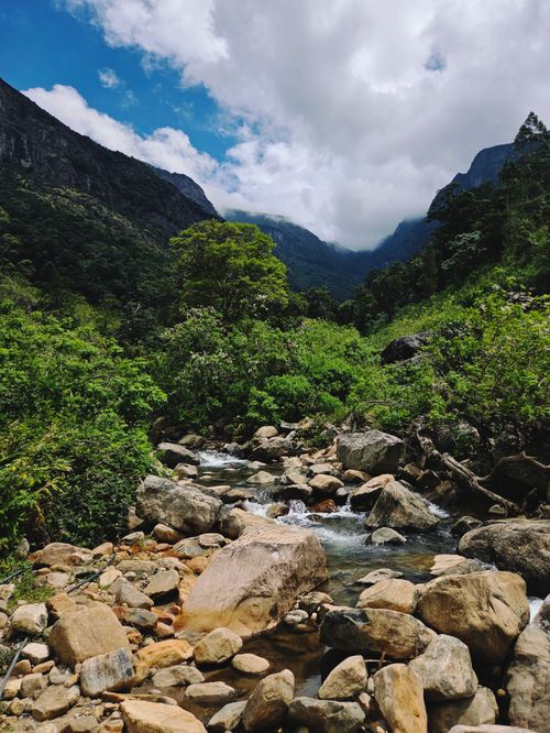 Free Lush green valley and flowing stream in Sri Lanka's mountainous region, perfect for travel and nature apps. Stock Photo