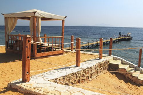 Free Charming beach cabana and pier by the ocean, perfect for serene escapes. Stock Photo