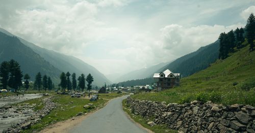 Free Picturesque valley road surrounded by mountains and lush greenery. Stock Photo