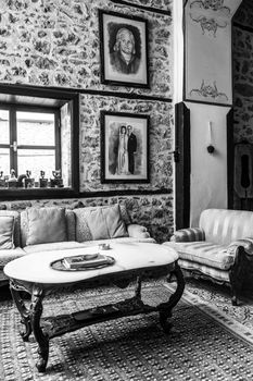 Elegant living room with stone walls and vintage furniture in a black and white setting.