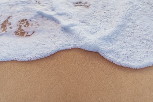 Free Gentle ocean waves lapping onto the sandy shore at Marawila, Sri Lanka, create a tranquil beach scene. Stock Photo