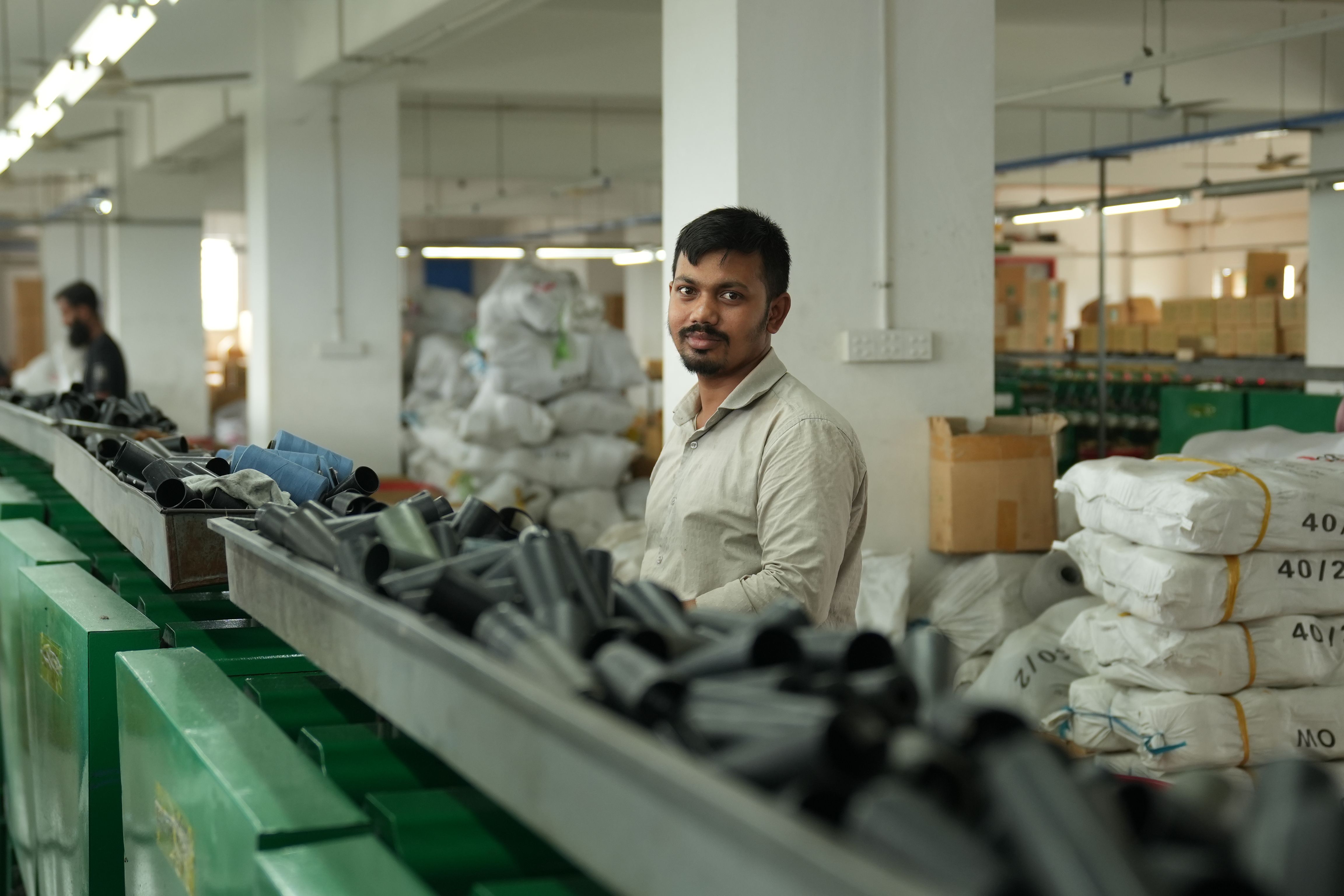 A worker in a modern factory surrounded by materials, conveying focus and industry.