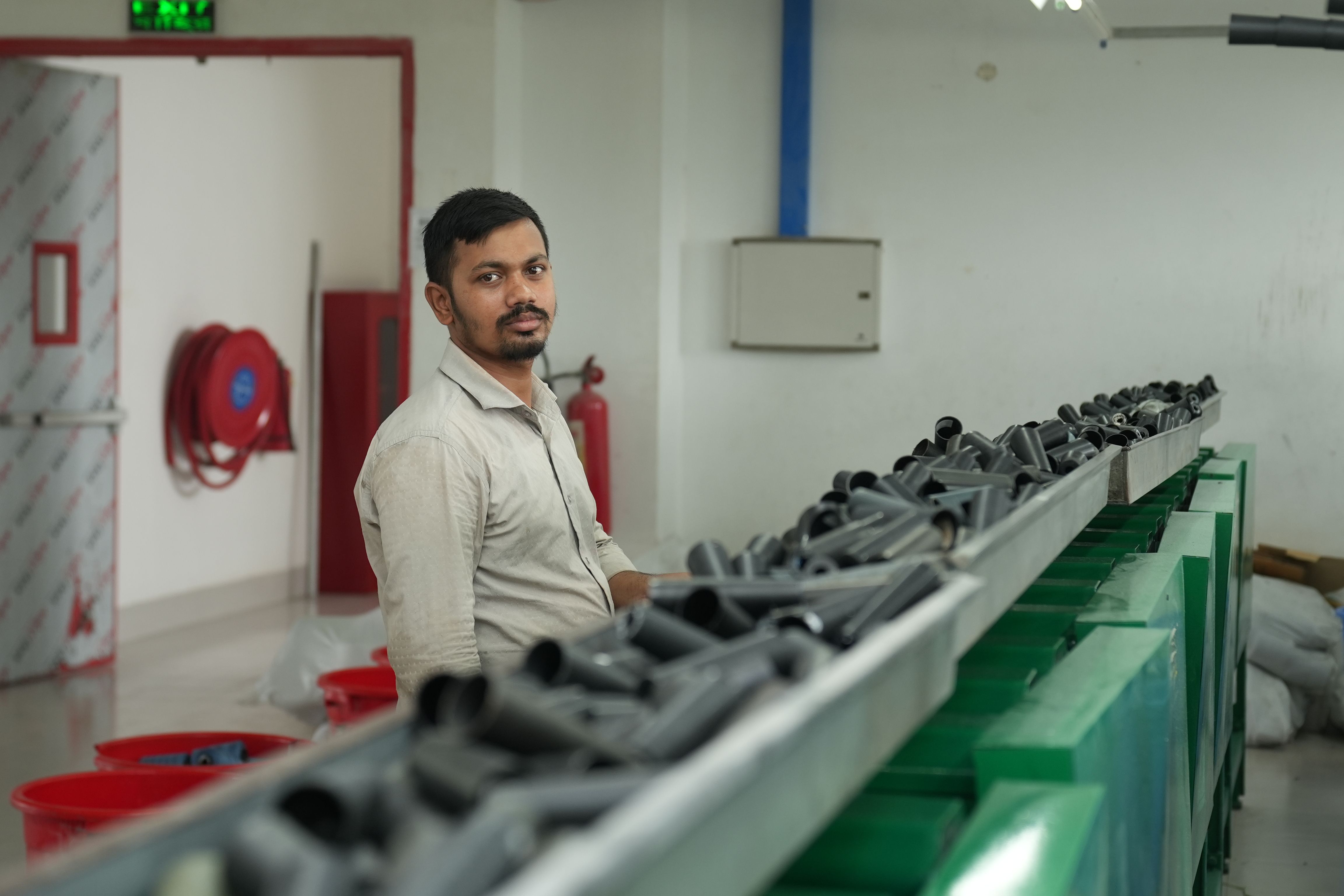 Factory worker monitoring a conveyor belt transporting materials