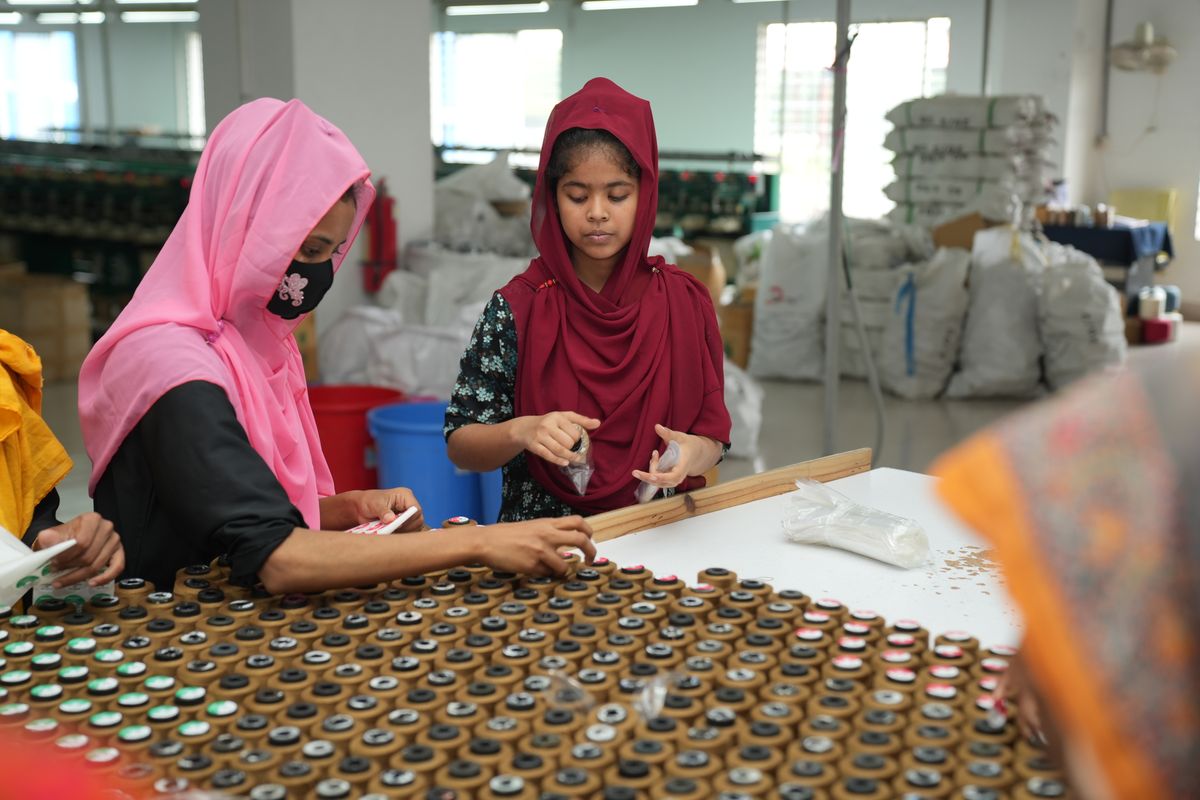 Workers assembling small components in a factory in Bangladesh