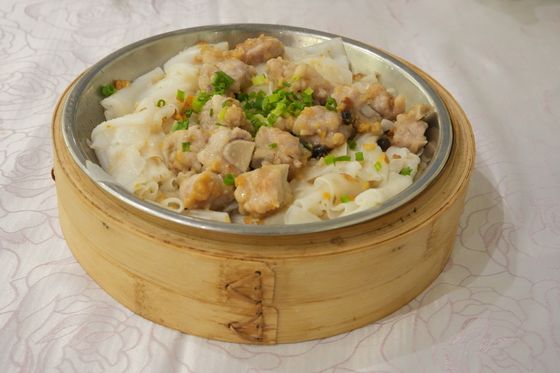 Steamed pork spareribs with black beans and scallions over wide rice noodles in bamboo steamer