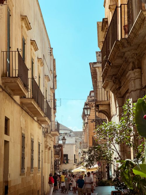Free Quaint historic street in Lecce, Italy, showcasing classic architecture under a clear blue sky. Stock Photo