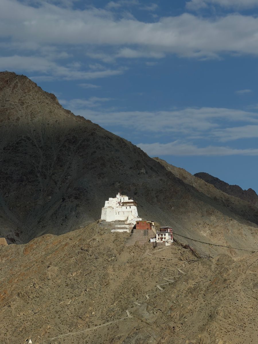 A white monastery on a rocky ridge above Leh