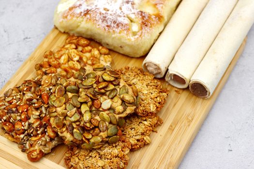 Delicious variety of European pastries featuring nut and seed toppings on a wooden board.
