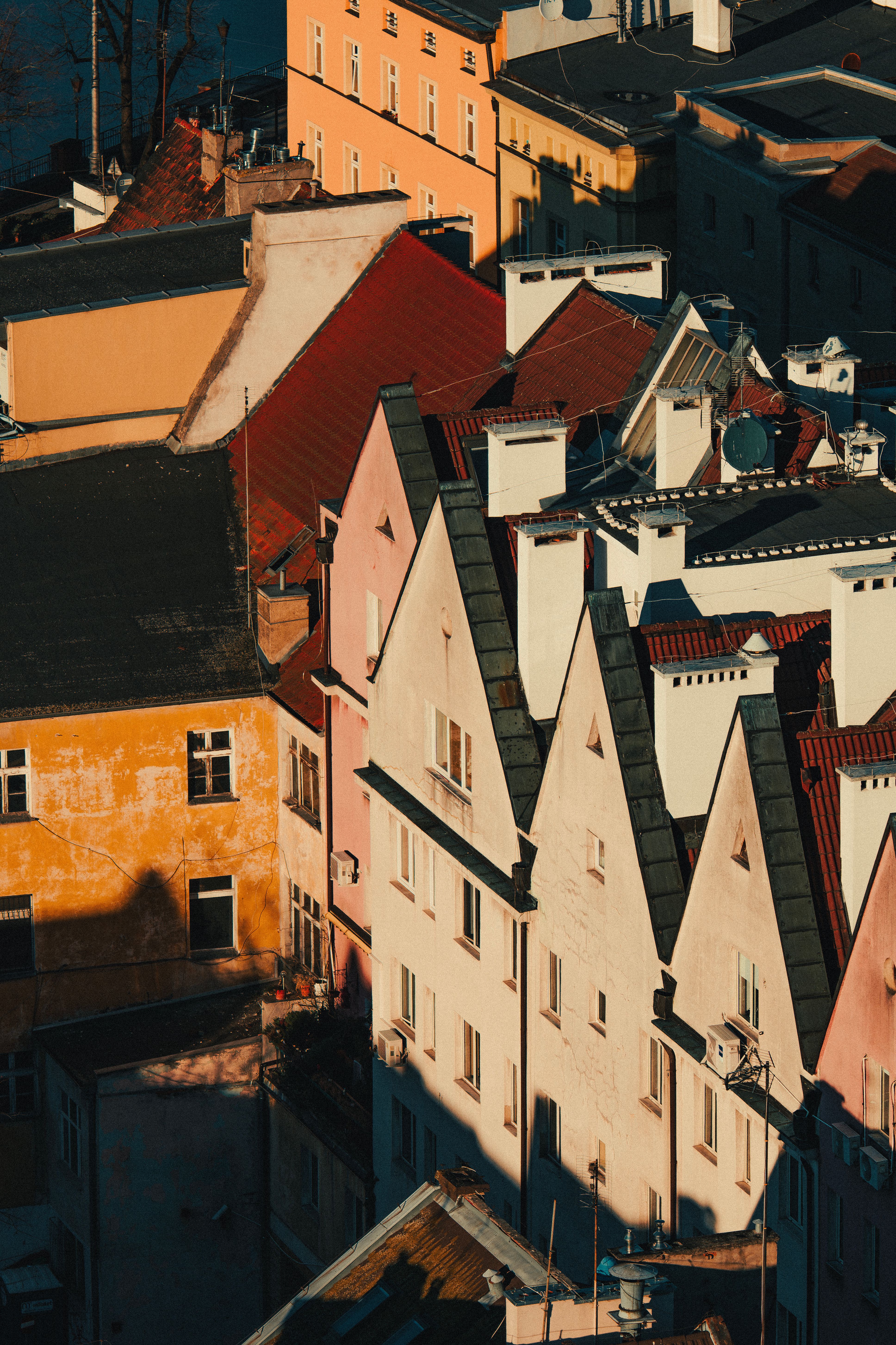 A picturesque aerial view of colorful rooftops in soft sunset light, highlighting European architectural style.