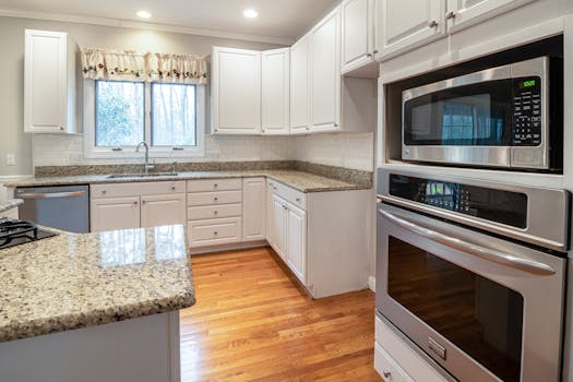 Spacious modern kitchen with white cabinets and granite countertops.
