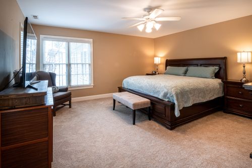 Free Spacious bedroom with elegant furniture and warm lighting, showcasing modern interior design. Stock Photo