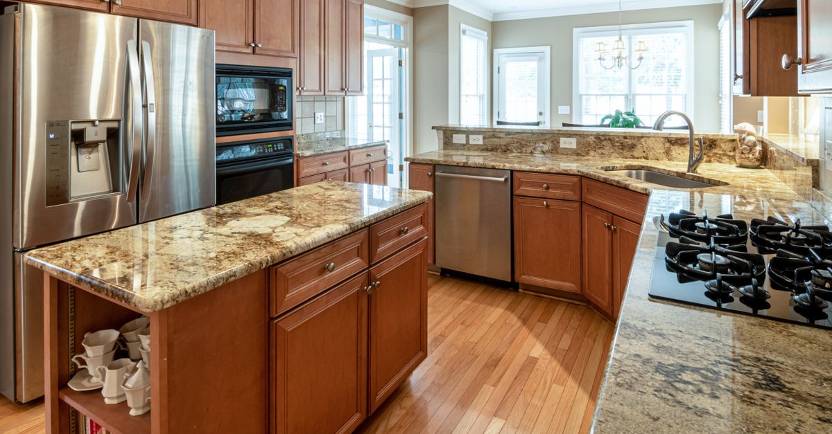 A luxurious kitchen interior featuring granite countertops and modern appliances.