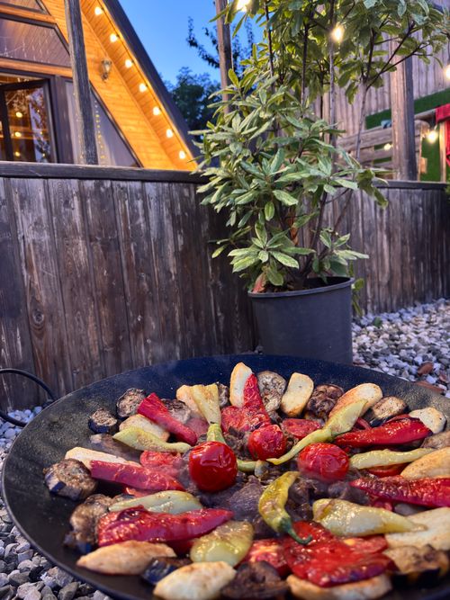 Free Delicious array of grilled vegetables served outdoors in a rustic cabin setting. Stock Photo