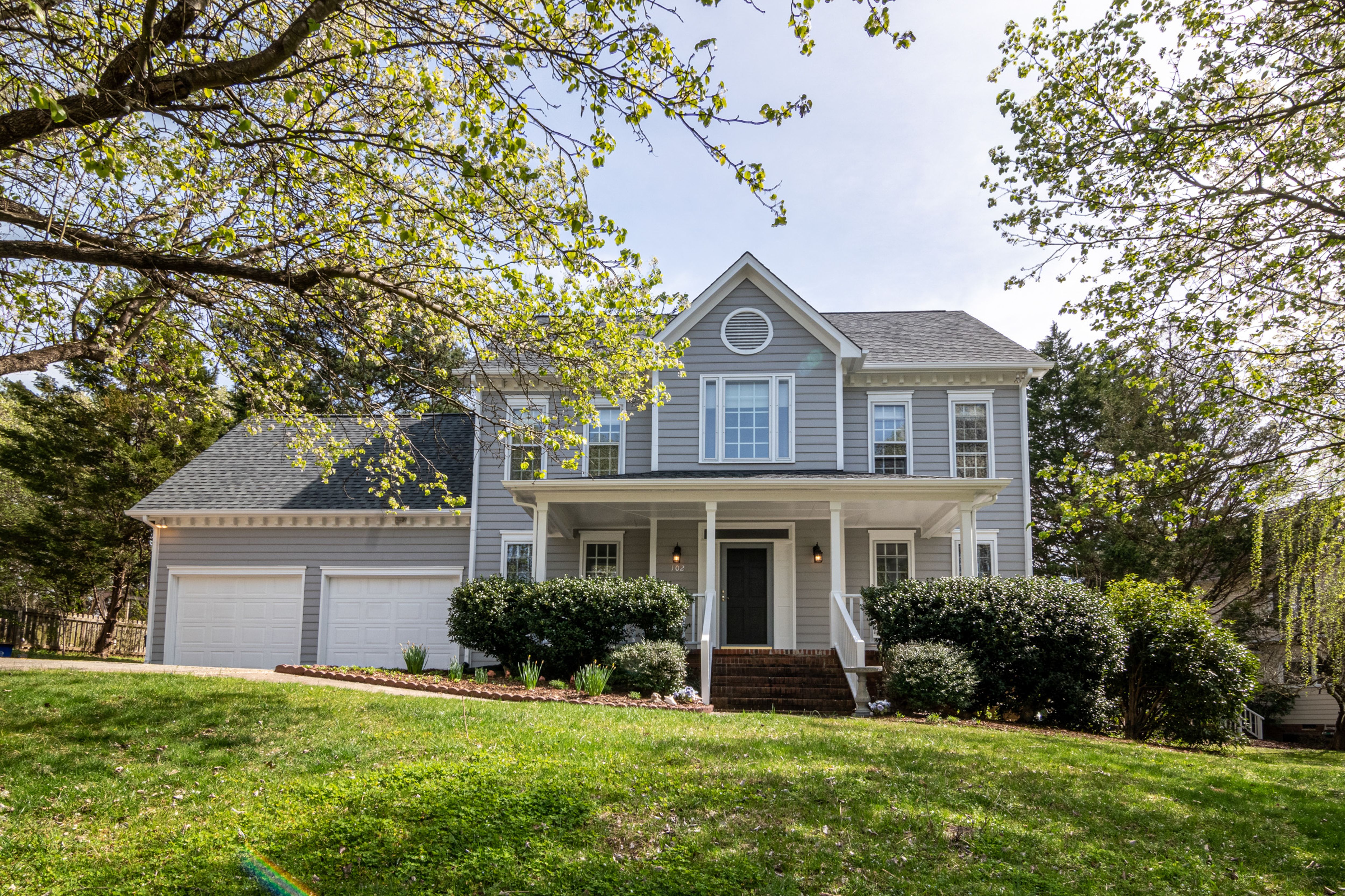 Image Alt Text: A house with a lawn and trees