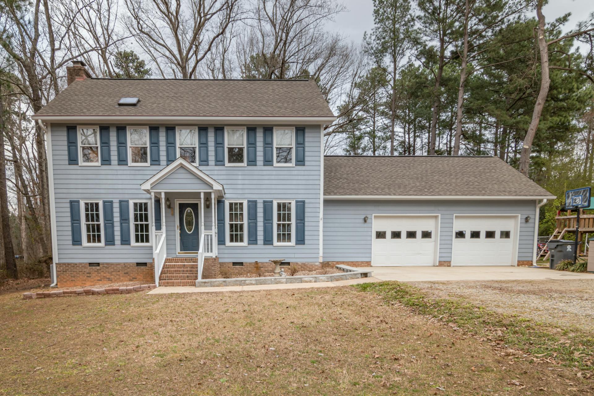 Charming two-story home with garage and spacious lawn, perfect for family living.