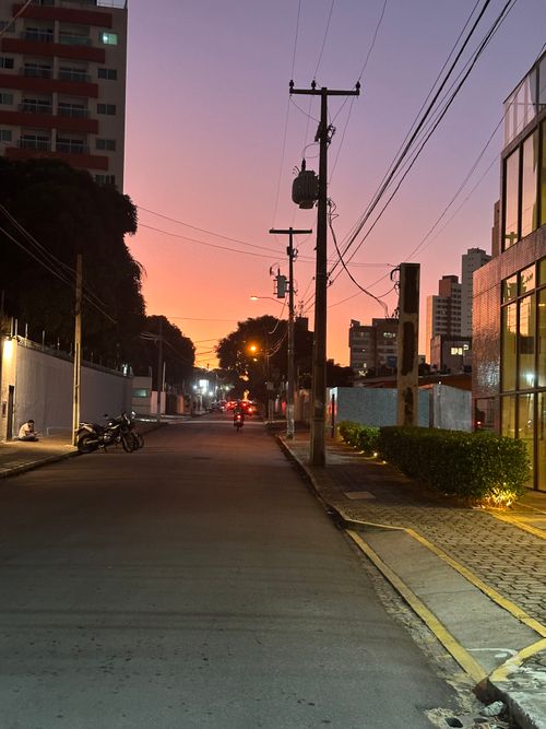 Free Tranquil street scene at dusk in a Brazilian city with a stunning sunset sky. Stock Photo