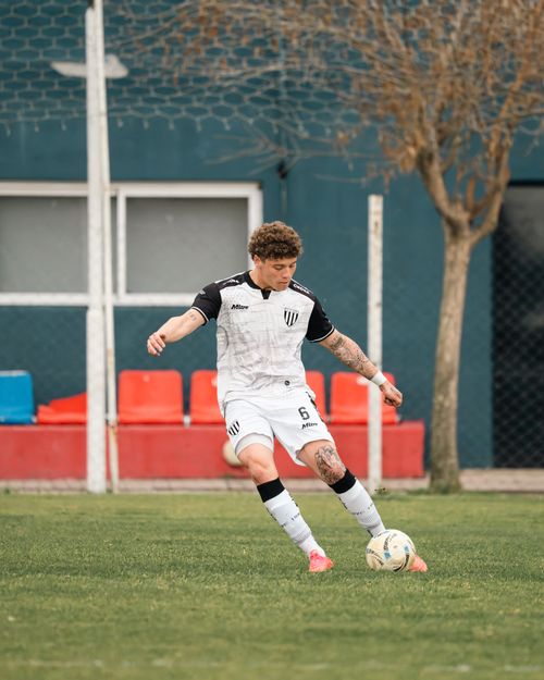 Free A young adult male soccer player in action on a grassy field during the day. Stock Photo