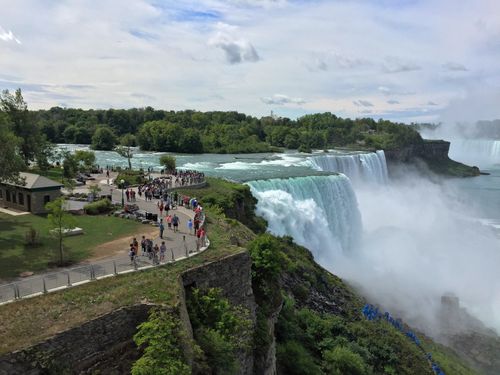 Free A stunning aerial view of Niagara Falls with tourists enjoying the scenic overlook on a pleasant day. Stock Photo