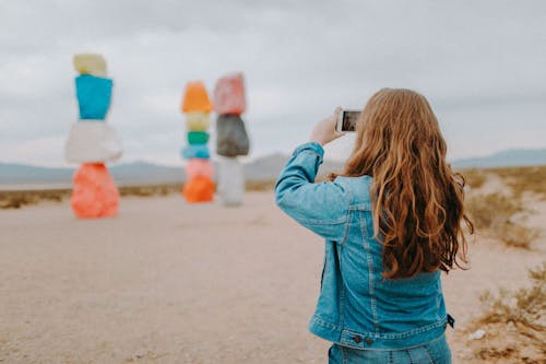 Woman In Blue Denim Jacket Taking Photos