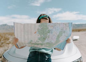 Woman Looking At The Map nach einer Reiserücktrittsversicherung