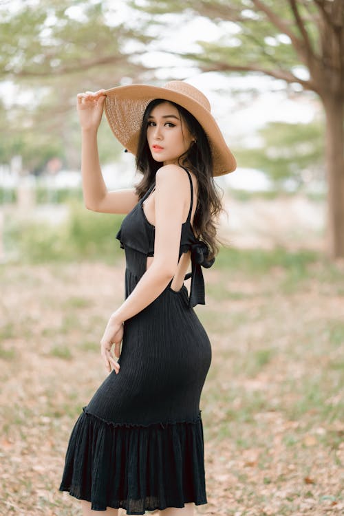 Woman in Black Spaghetti Strap Dress Wearing Brown Straw Hat
