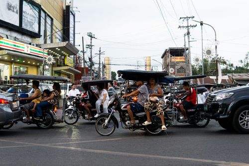 Free Busy street scene with tricycles and pedestrians in the Ilocos Region, Philippines. Stock Photo