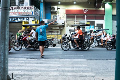 Free Vibrant street scene in Ilocos Region, Philippines, showcasing local tricycle traffic and daily life. Stock Photo