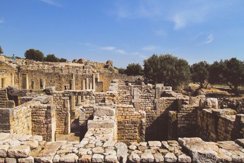 Free Explore the historic ruins of Dougga, Tunisia, under a clear blue sky. Perfect for travel and history enthusiasts. Stock Photo