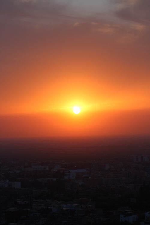 Free Stunning sunset casting warm hues over Béni Mellal cityscape in Morocco. Stock Photo