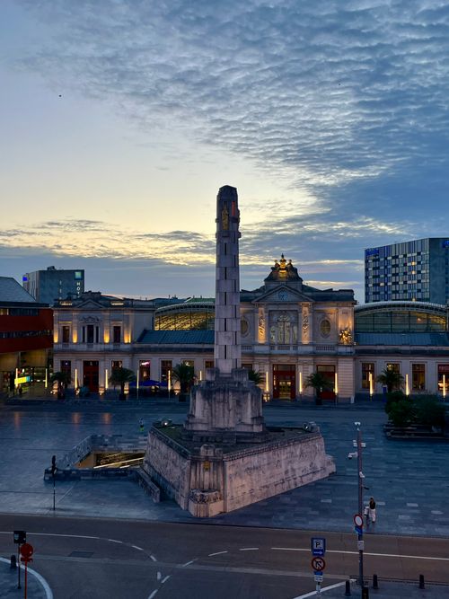 Free A stunning view of a monument in Leuven, Belgium, captured at sunset with vivid clouds overhead. Stock Photo